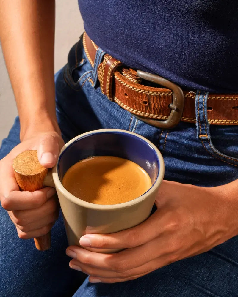 Hands holding a Témplica mug with coffee